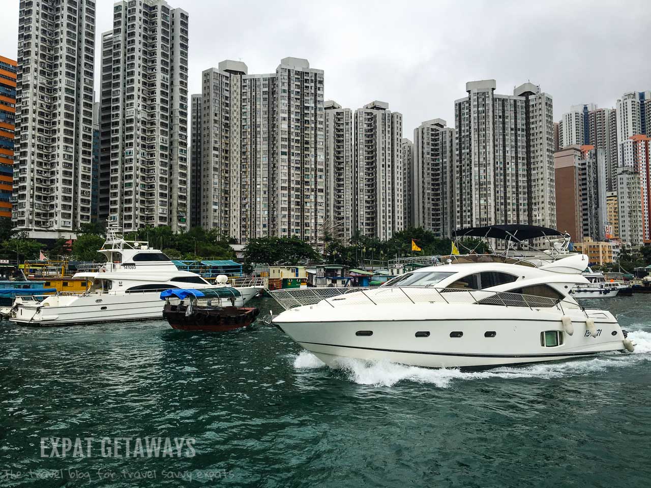 A sampan slips past a luxury yacht. Only in Hong Kong...